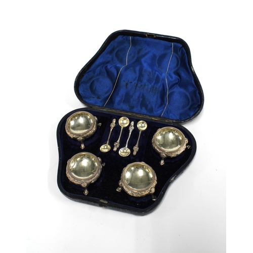 99H - A cased set of four Victorian silver salts with four white metal condiment spoons, Sheffield 1867