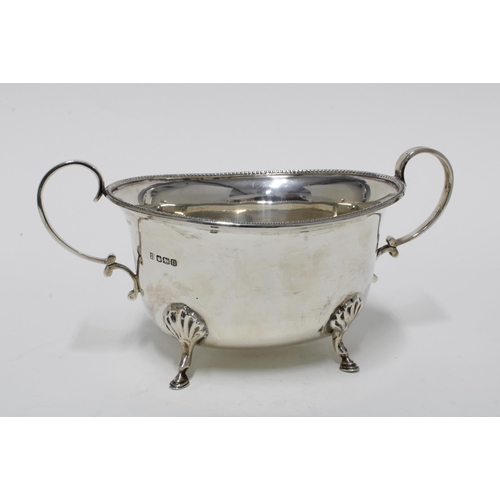 75 - George V silver twin handled bowl, standing on four hoof feet, Sheffield 1930, 20cm long