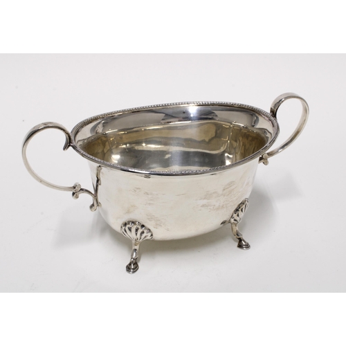 75 - George V silver twin handled bowl, standing on four hoof feet, Sheffield 1930, 20cm long