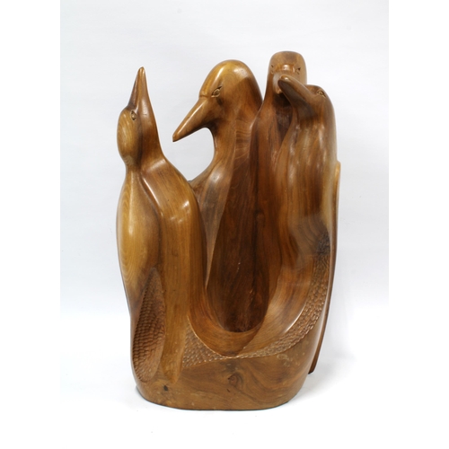 403 - A carved wooden group of four penguins, signed with a monogram, 42cm