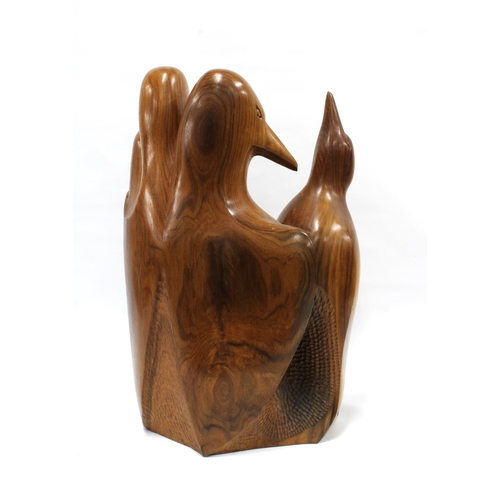 403 - A carved wooden group of four penguins, signed with a monogram, 42cm