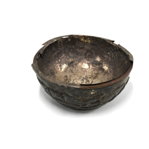 409 - 19th century carved coconut bowl with a white metal liner, (a/f) 13cm diameter