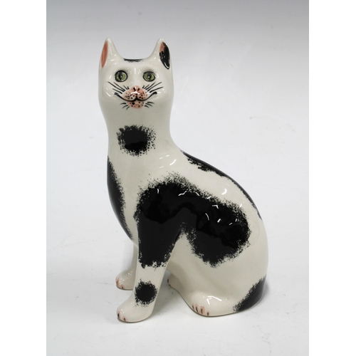 114 - Griselda Hill Pottery Wemyss black and white cat, with painters initials RR, 11 x 17cm.