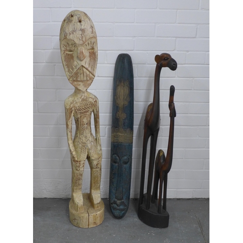 243 - An African carved wooden mask, camel figure group and a carved floor standing male figure,  123cm hi... 