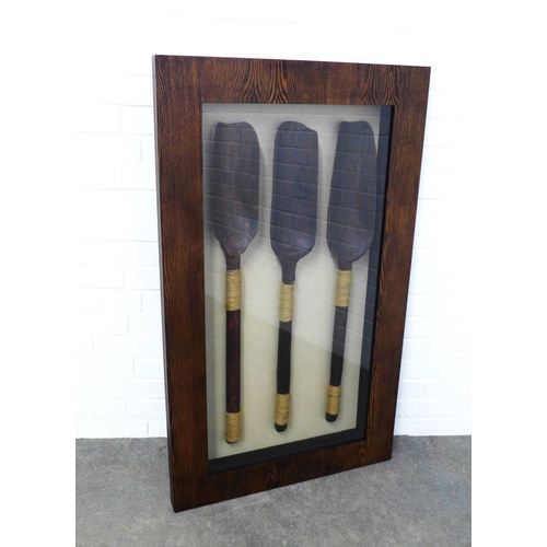 304 - Framed showcase with tribal paddles, 70 x 120cm.