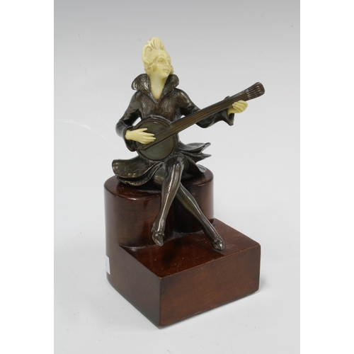 372 - An Art Deco style bronze and faux ivory figure of a female minstrel banjo player, on a stepped woode... 