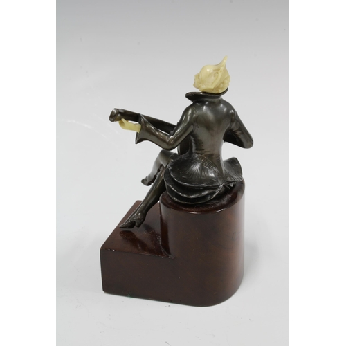 372 - An Art Deco style bronze and faux ivory figure of a female minstrel banjo player, on a stepped woode... 