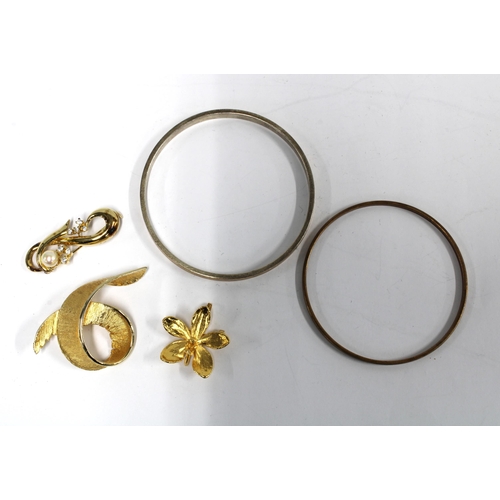 83 - A gold plated bangle and another, costume jewellery brooches