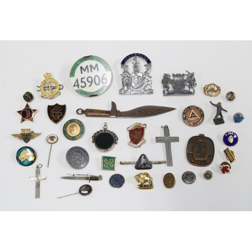 390 - A collection of badges and lapel pins, bus Conductors badges, a silver bloodstone revolving fob, min... 