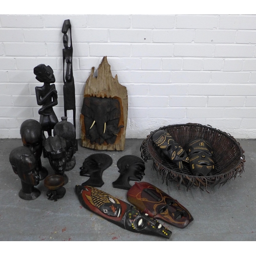 437 - A quantity lot of wooden face masks, carved African figures and a basket, etc