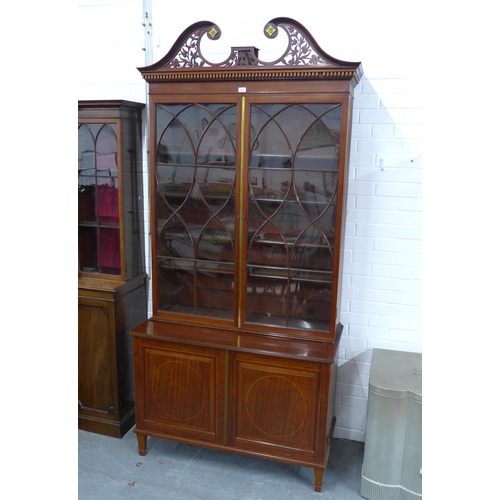 299 - Mahogany bookcase cabinet with swan neck fretwork top and dentil frieze over a pair of astragal glaz... 