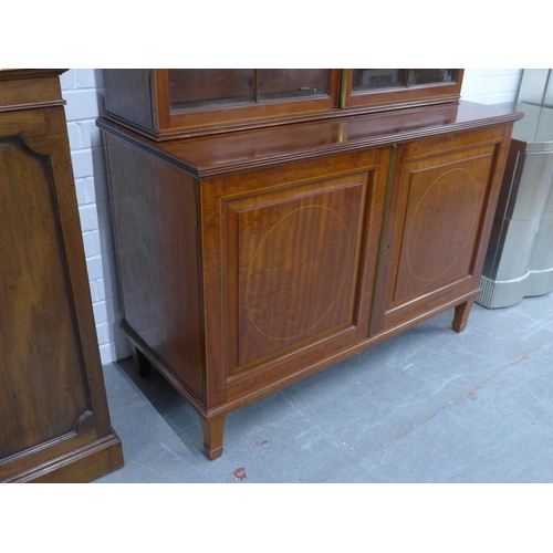 299 - Mahogany bookcase cabinet with swan neck fretwork top and dentil frieze over a pair of astragal glaz... 