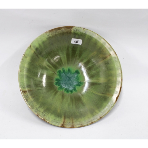 402 - Studio pottery bowl with green streaked glaze, 36cm diameter