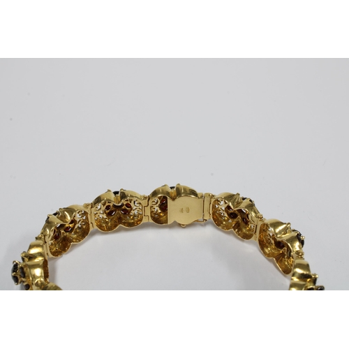 63 - 18ct gold bracelet with eleven panels, each with a group of seven garnets in a flowerhead setting, s... 