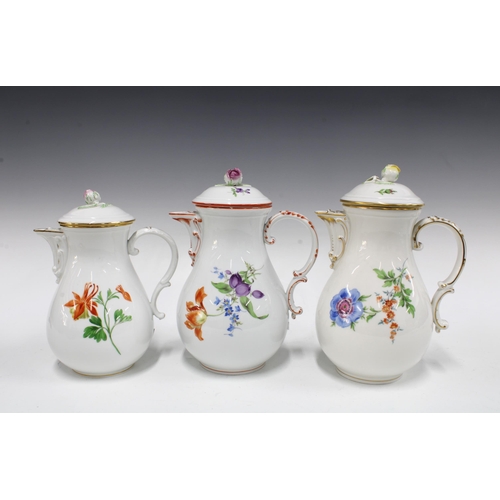 128 - Three Meissen coffee pots of baluster form and painted with flowers, each with a rosebud finial (3) ... 