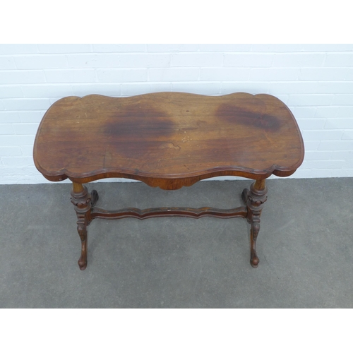 239 - Victorian mahogany table, shaped top on carved end supports with wavy stretcher, 167 x 69 x 53cm.