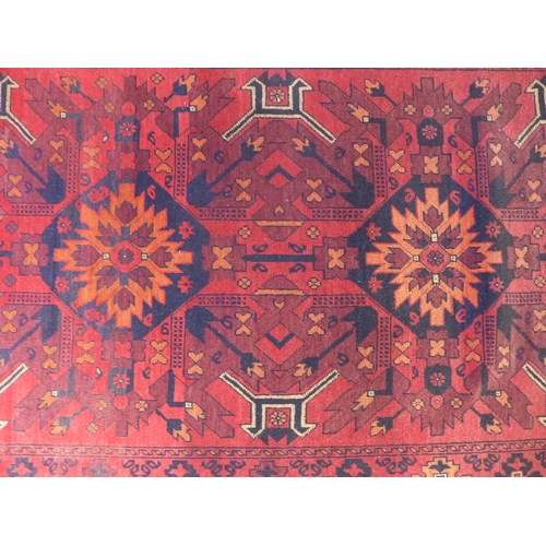 295 - Persian / Afghan rug with red field, 208 x 130cm.