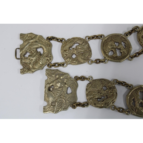 56 - Chinese white metal belt, with thirteen dragon and Buddhistic lion panels with a central two part bu... 