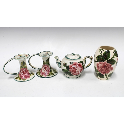 111 - Wemyss ware handpainted cabbage rose pottery to include a pair of chamber candlesticks and small tea... 