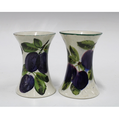 120 - Wemyss ware, a pair of handpainted plums pattern vases of waisted form, painted marks (2) 8 x 11cm.