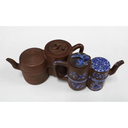 135 - Two Yixing stoneware conjoined teapots, one set with blue and overglaze pattern (2) 22cm wide.