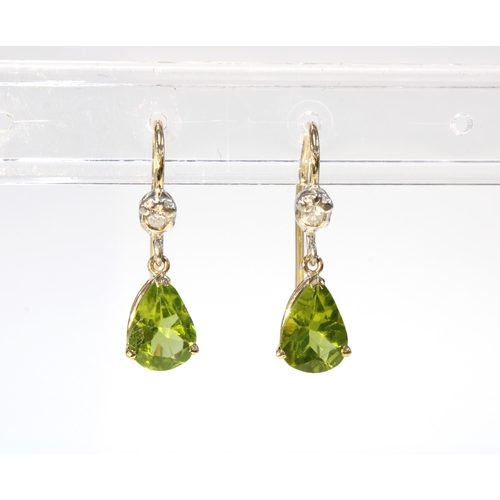 15 - A pair of peridot and diamond drop earrings, each set with a bright cut diamond above a pear shaped ... 