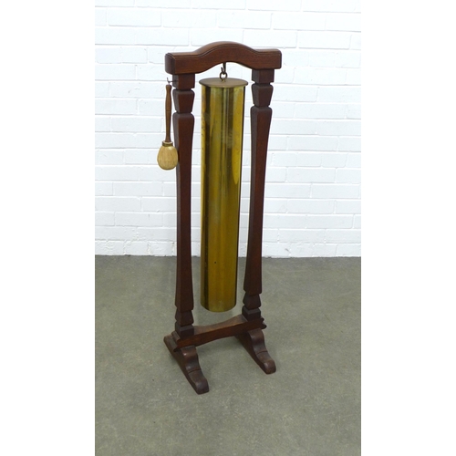 213 - WWI brass shell case dinner gong in an oak stand, 35 x 109cm.