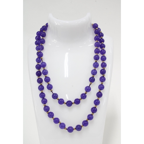 25 - A strand of lilac purple jadeite beads with yellow metal spacers,