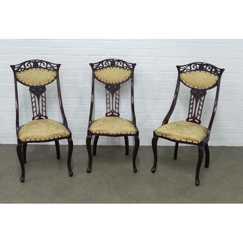 252 - Set of three art nouveau mahogany  side chairs, with stylised pierced top rial and fruit carved spla... 