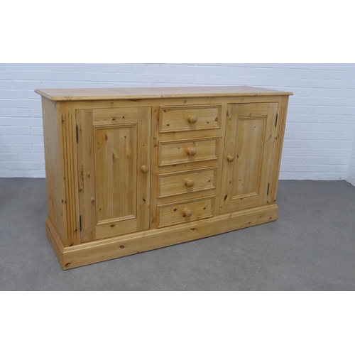 256 - Pine low dresser, the rectangular top above four short central drawers, flanked by cupboard doors an... 