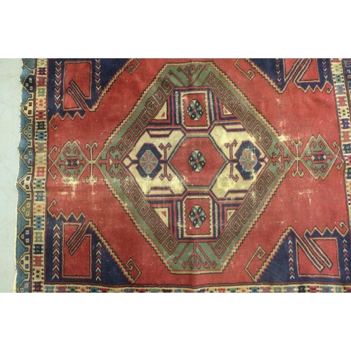 275 - Turkish rug, red field with blue spandrels and central medallion with hooked border, 150 x 114cm.