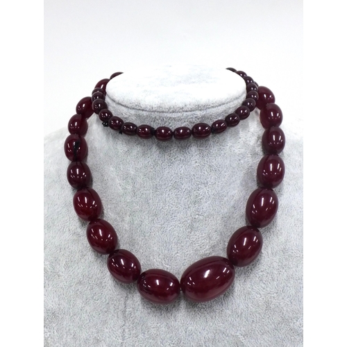 11 - Early 20th century graduating strand of faux cherry amber beads,