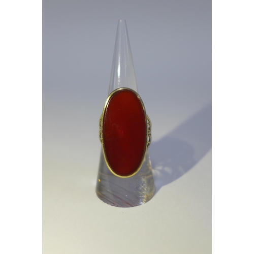 15 - 9ct gold ring with an oval carnelian on a pierced shank with London hallmarks