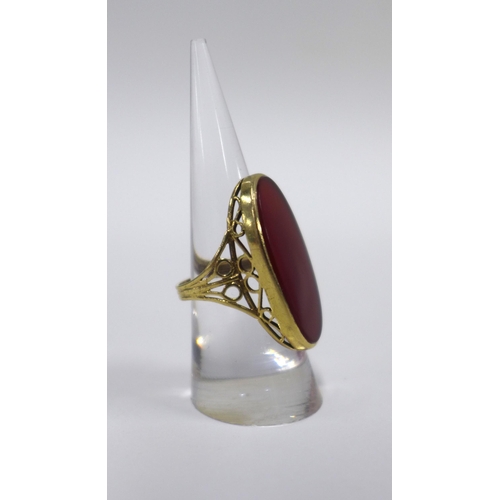 15 - 9ct gold ring with an oval carnelian on a pierced shank with London hallmarks