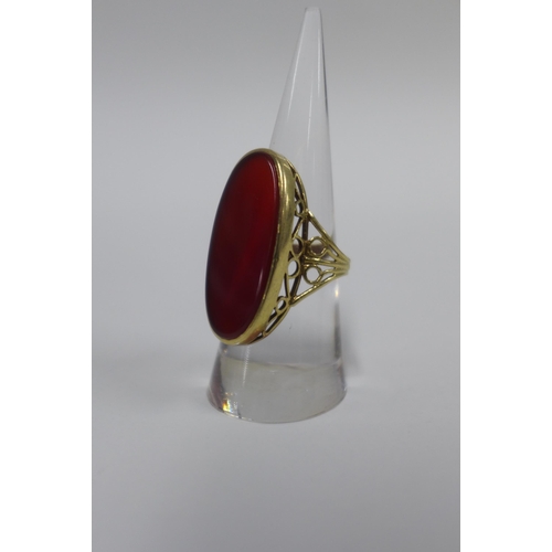 15 - 9ct gold ring with an oval carnelian on a pierced shank with London hallmarks