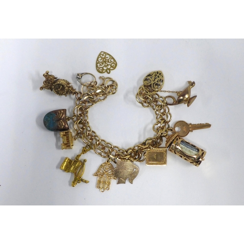 16 - 9ct gold charm bracelet with a quantity of mainly 9ct gold charms, (USA flag not hallmarked and like... 