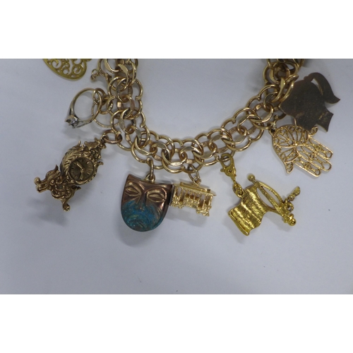 16 - 9ct gold charm bracelet with a quantity of mainly 9ct gold charms, (USA flag not hallmarked and like... 