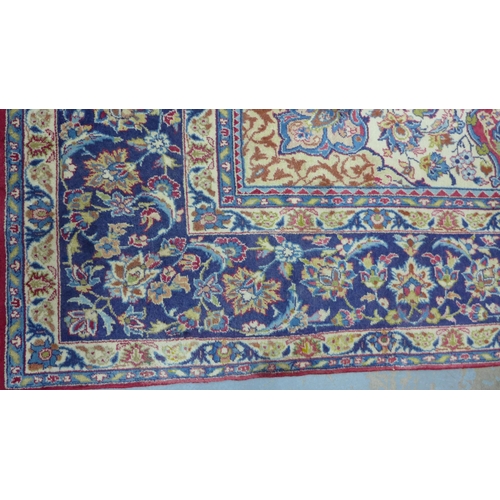 212 - Isfahan carpet, central medallion and red field with scrolling vines, indigo border, 490 x 305cm.