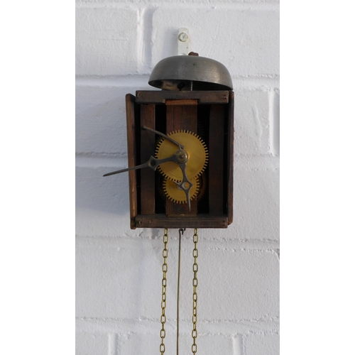 390 - Small wall mounted wooden clock, a/f with no face and one cherub pendulum, 9 x 15cm