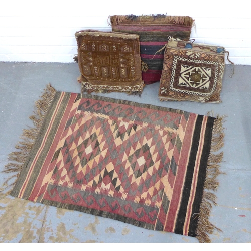 402 - Three bagface  cushions together with a small kilim rug, 98 x 68cm (4)