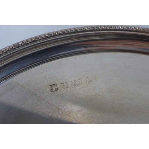 81 - Silver tray of circular form with a beaded edge, Birmingham 1986, 32cm diameter