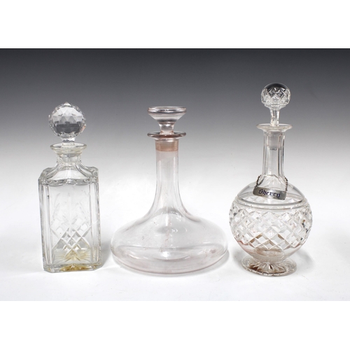 140 - Three glass decanters, including a ship's decanter, 15cm, and a silver sherry decanter label (3)