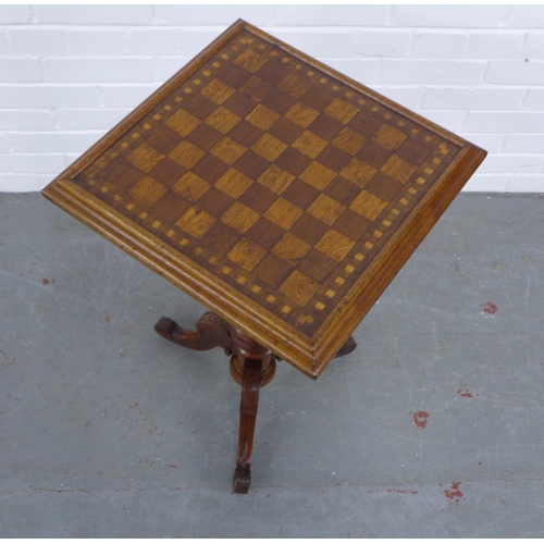 216 - An oak and mixed wood games table, with square checkerboard top with fluted column and carved tripod... 