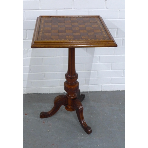 216 - An oak and mixed wood games table, with square checkerboard top with fluted column and carved tripod... 