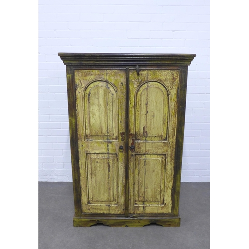 233 - An Indian cupboard with two panelled doors having a distressed painted finish, medium size and openi... 