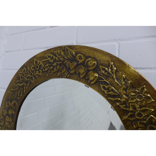 243 - Brass circular wall mirror with embossed fruit and flower frame, 48cm.