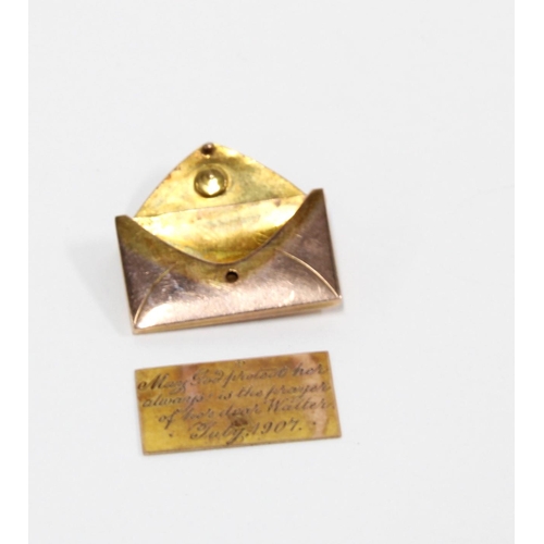 43 - An Edwardian rose coloured and gemset miniature envelope and letter charm, a yellow metal mounted am... 