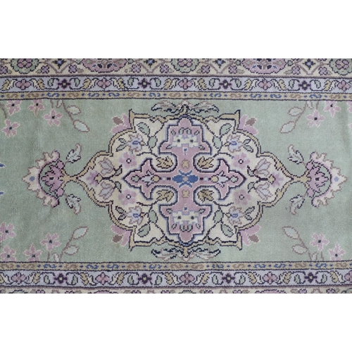 530 - Eastern wool rug with sage green field and foliate medallion,  201 x 97cm.