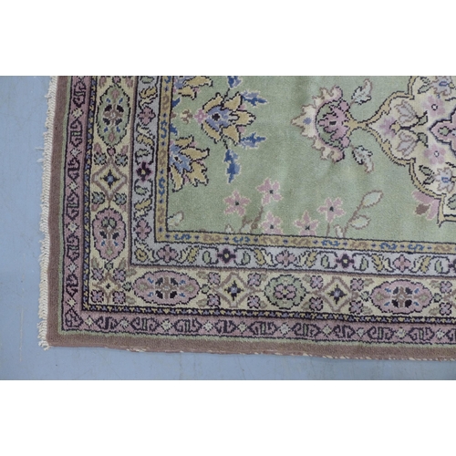 530 - Eastern wool rug with sage green field and foliate medallion,  201 x 97cm.