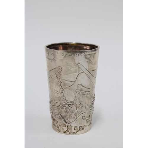 20 - Russian silver beaker with repoussé decoration of warrior heads, inscribed inscription and dated 191... 